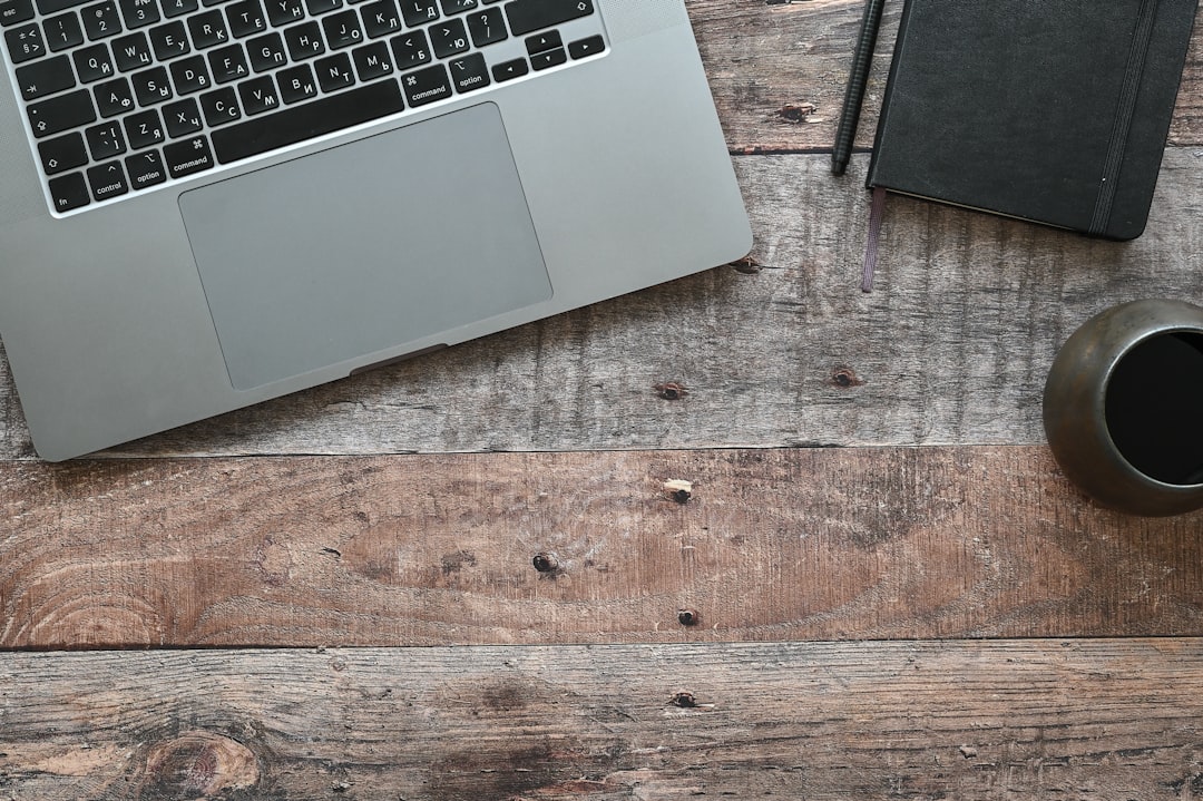 Overhead view of workspace with laptop, coffee, and trade publications