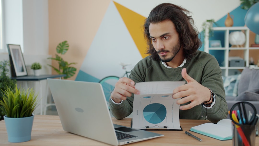 Business owner reviewing documents at a desk with laptop