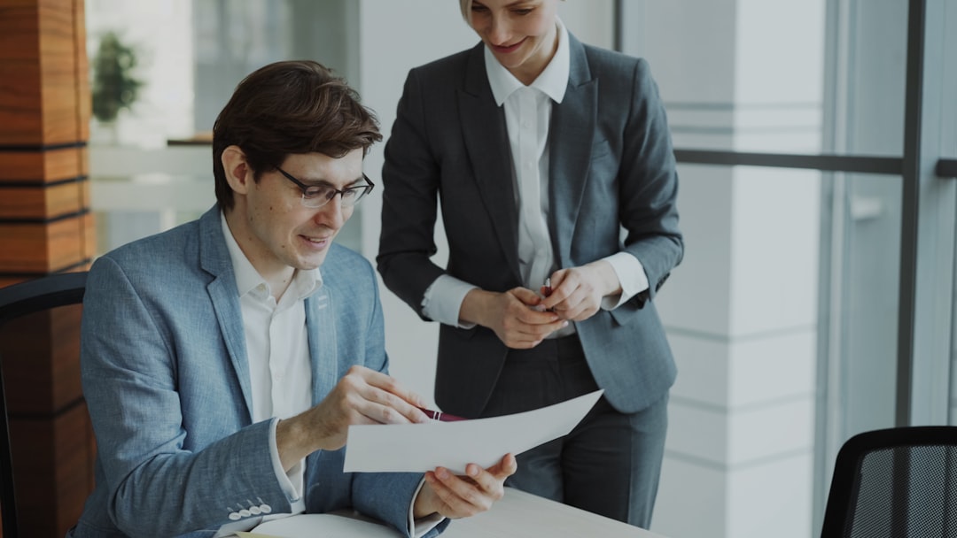 Two professionals reviewing loan documents at a table