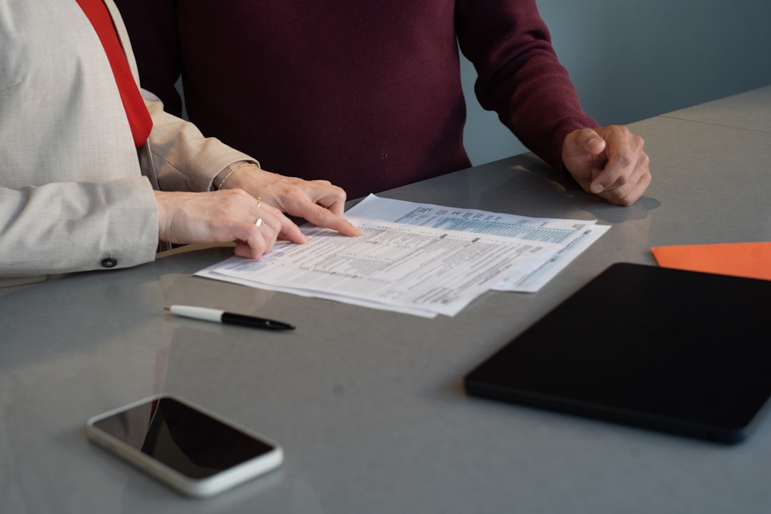 Business handshake across desk with documents