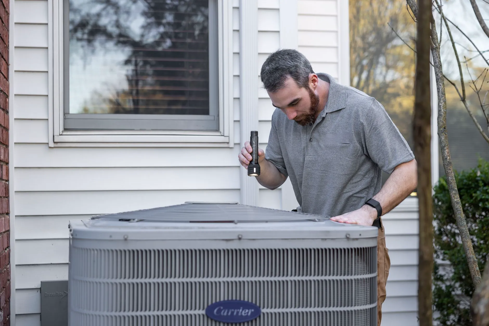 Heat pump outdoor unit being installed at a residential property by an HVAC technician
