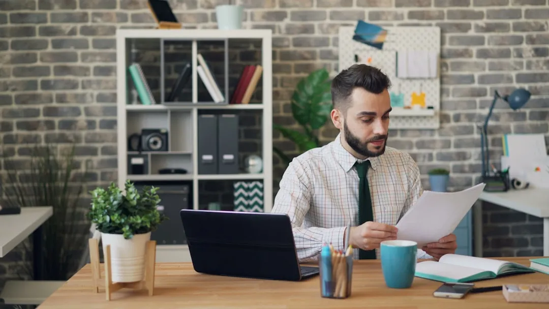 Business owner reviewing insurance documents and paperwork at office desk