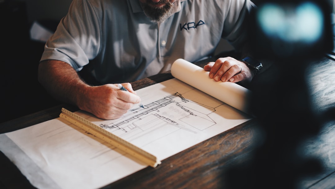 Project manager reviewing construction blueprints and architectural drawings at a desk