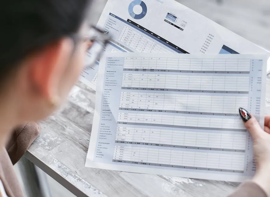 Businesswoman reviewing financial spreadsheets with charts and graphs in an office