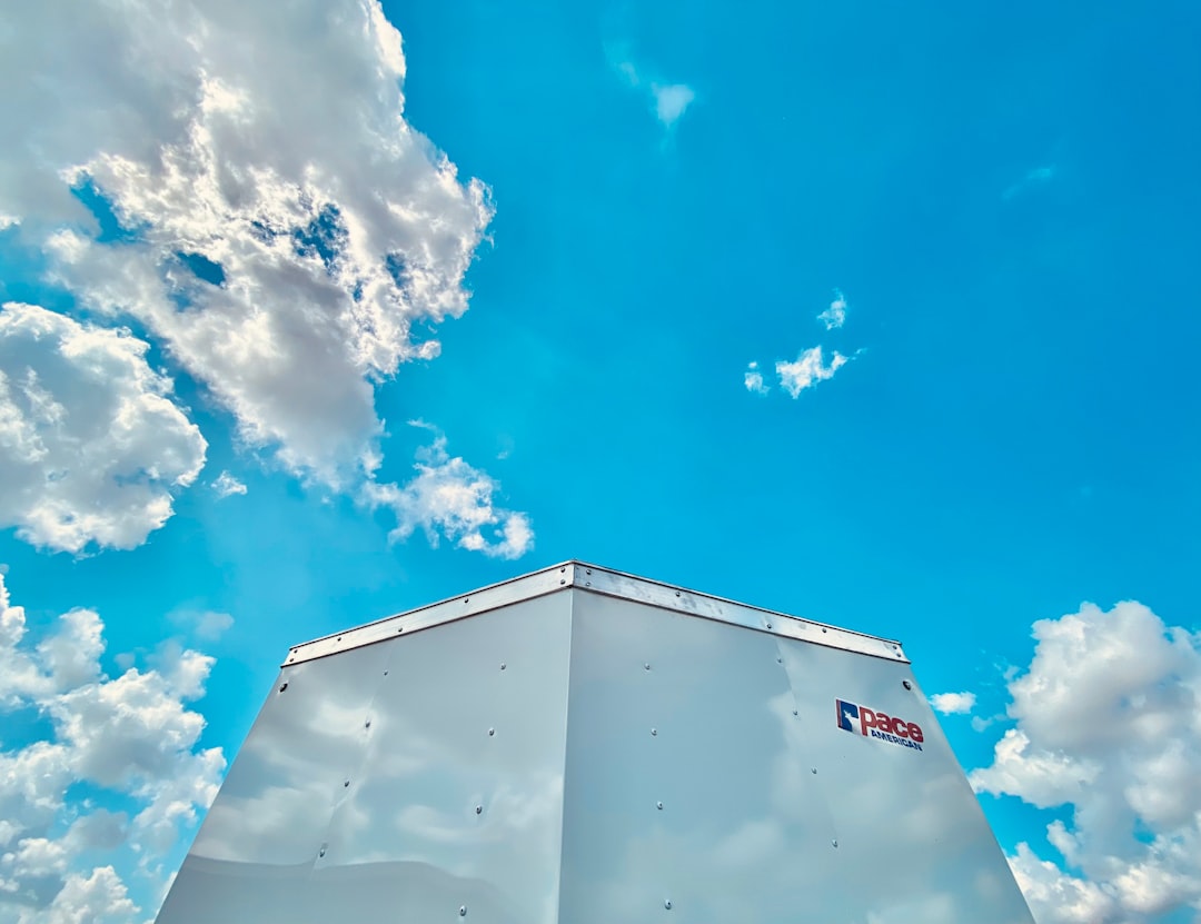 HVAC technician working on a commercial rooftop unit under a clear blue sky
